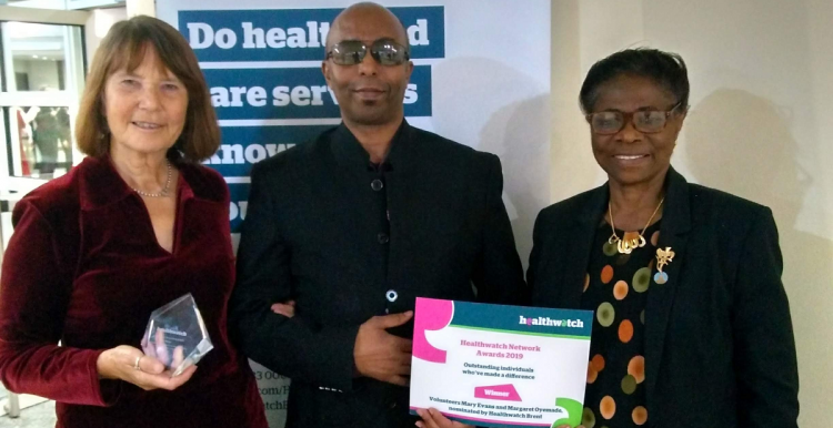 Two Healthwatch Brent volunteers and a member of staff receiving award certificate 