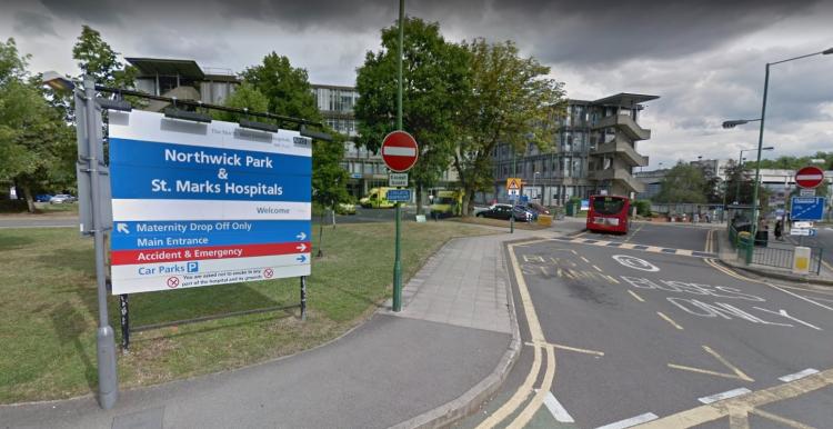 This is a picture of outside of Northwick Park Hospital. On the left hand side is a grass area and the blue sign is saying 'Northwick Park & St Marks'