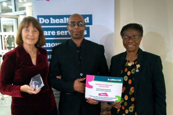 Two Healthwatch Brent volunteers and a member of staff receiving award certificate 