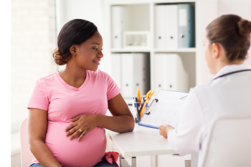 pregnant woman speaking to a doctor