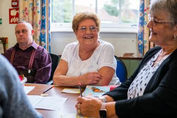 Women smiling at a community wellbeing group 