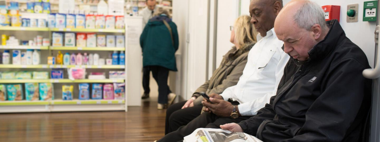 men waiting in pharmacy 